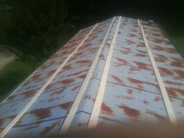 Rusted metal roof panels with new wood purlins before replacement — Storm Damage Roof Repair in Graysville by Roofing Brothers